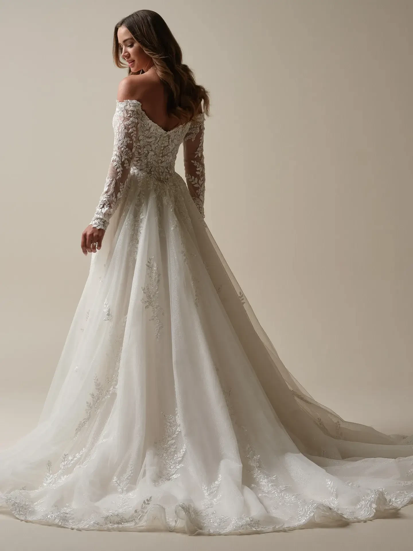 model is wearing an off the shoulder a-line lace bridal gown