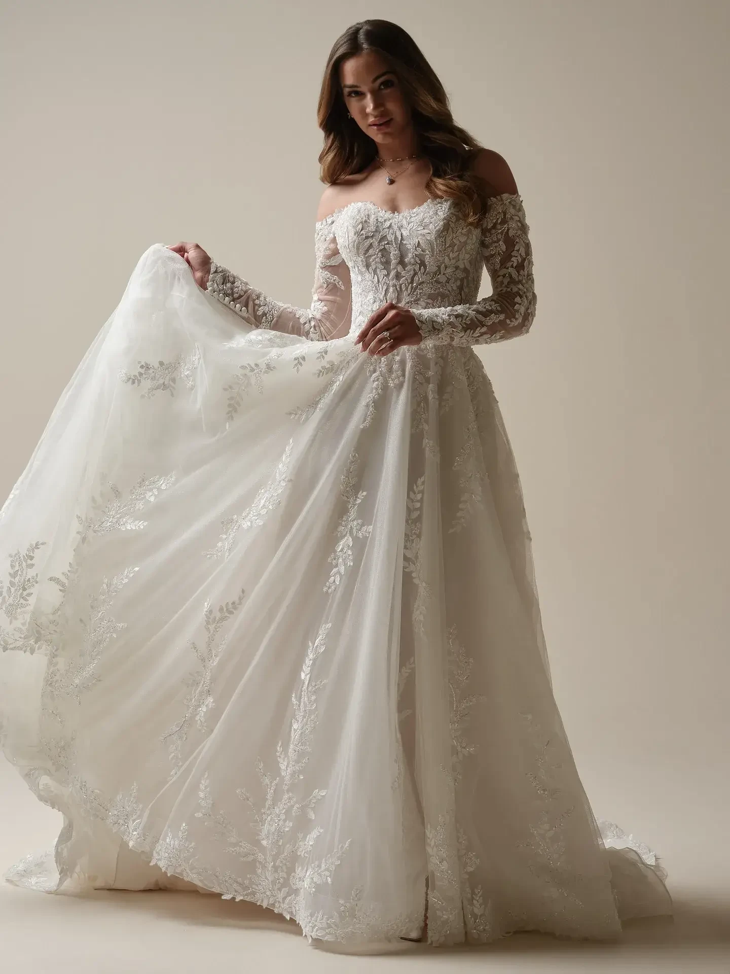 model is wearing an off the shoulder a-line lace bridal gown