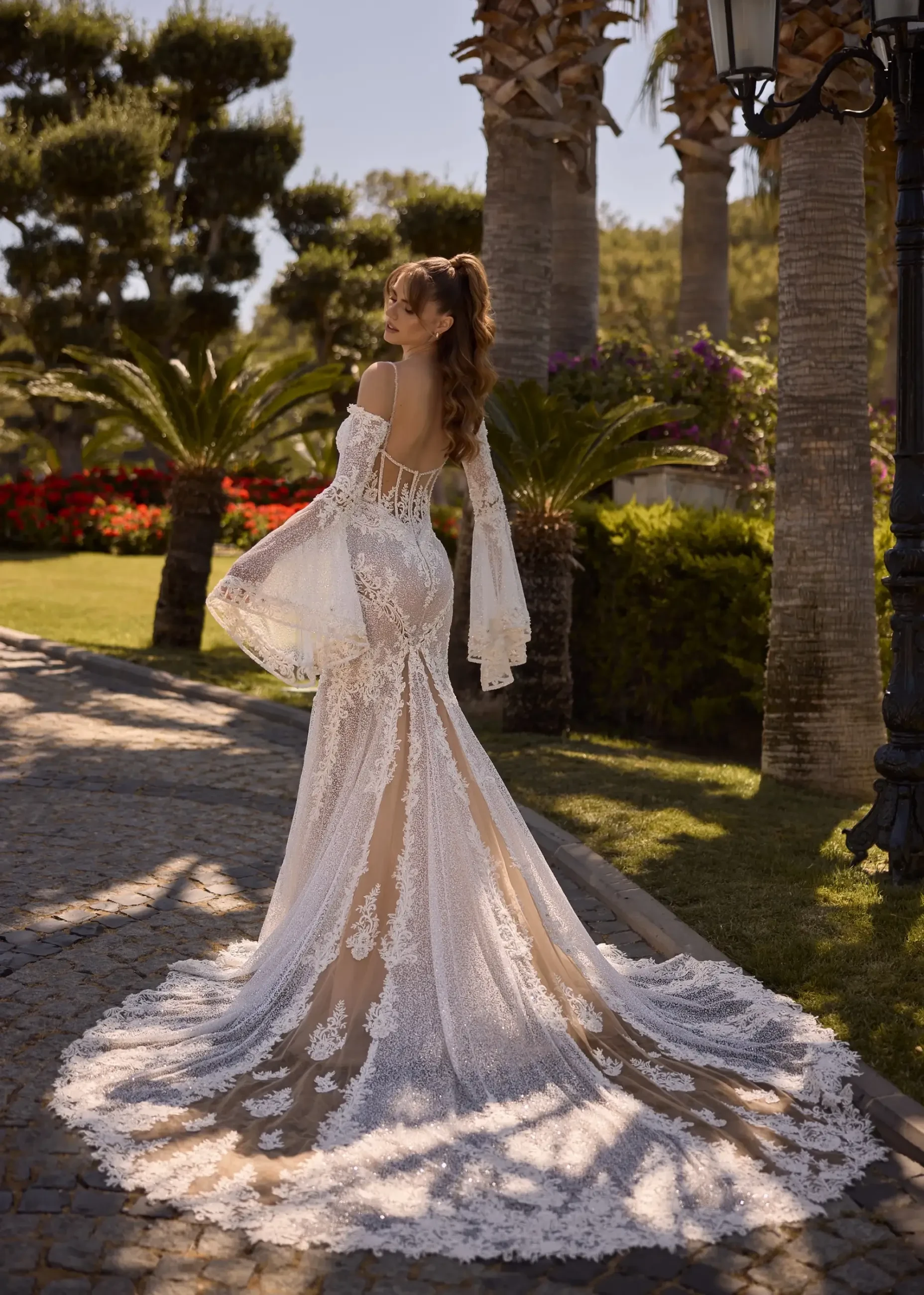 model is wearing a bohemian lace wedding dress with flowy sleeves