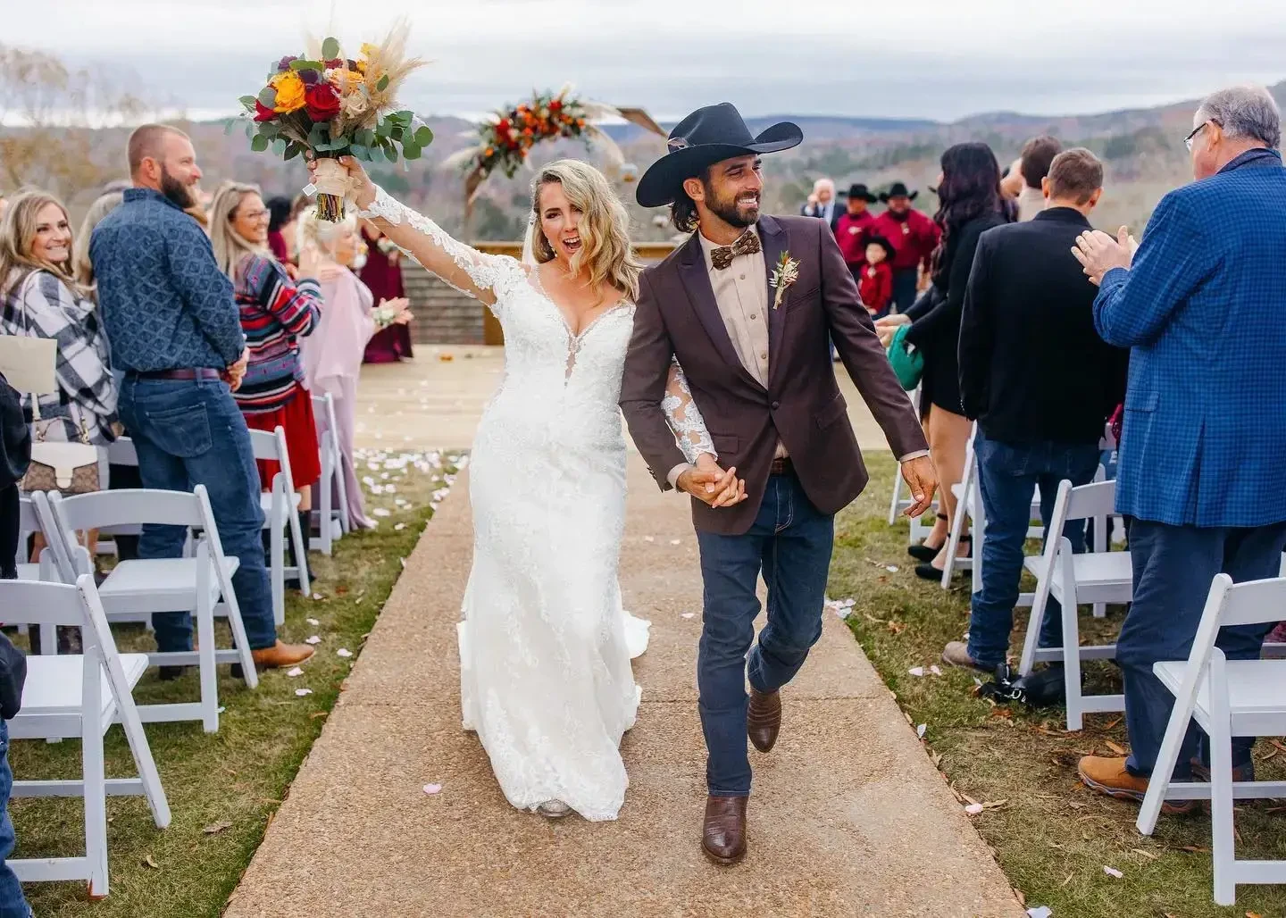 A bride and groom smile while walking back down the aisle after getting married