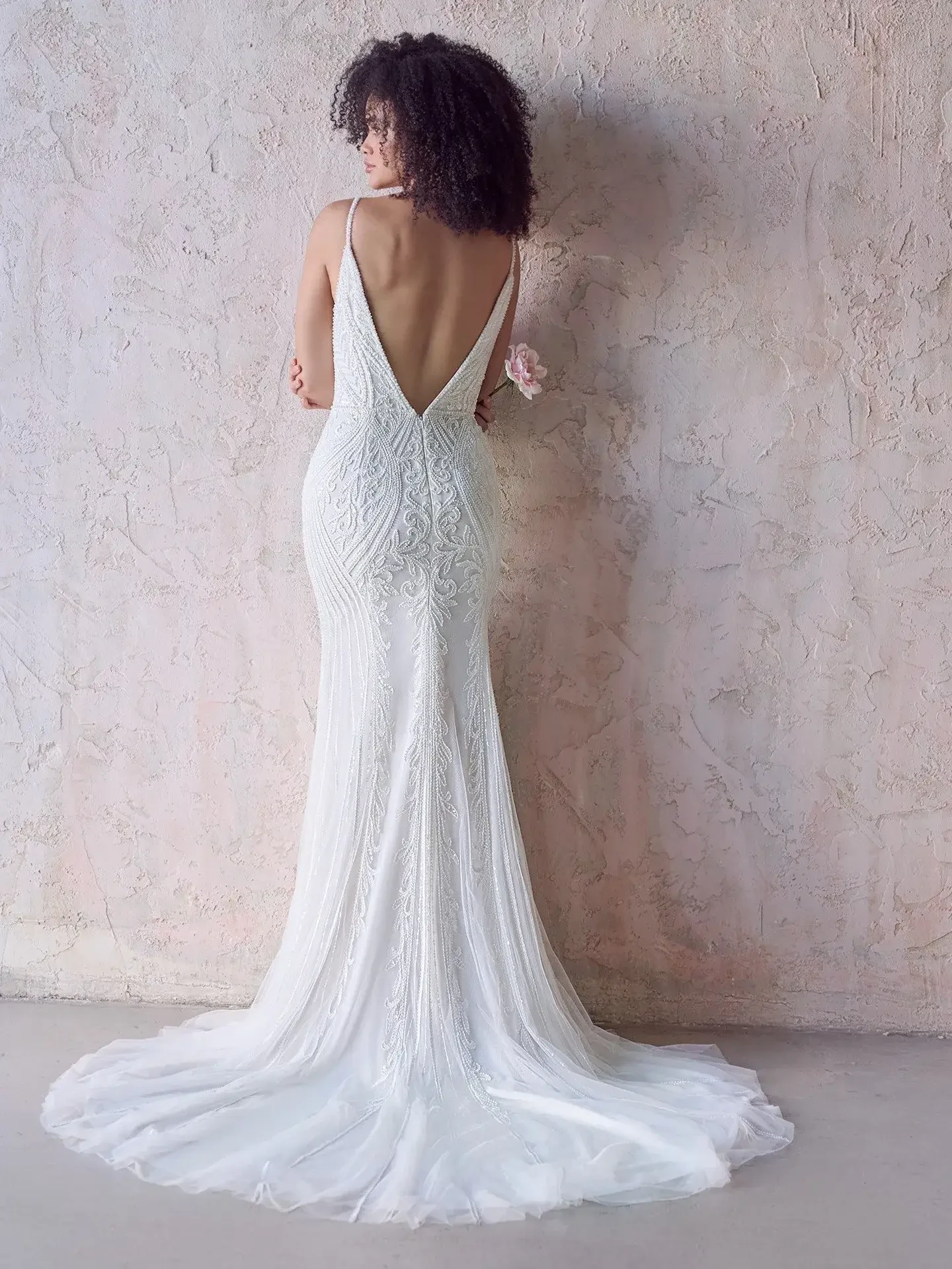model is wearing an open back sleeveless wedding dress