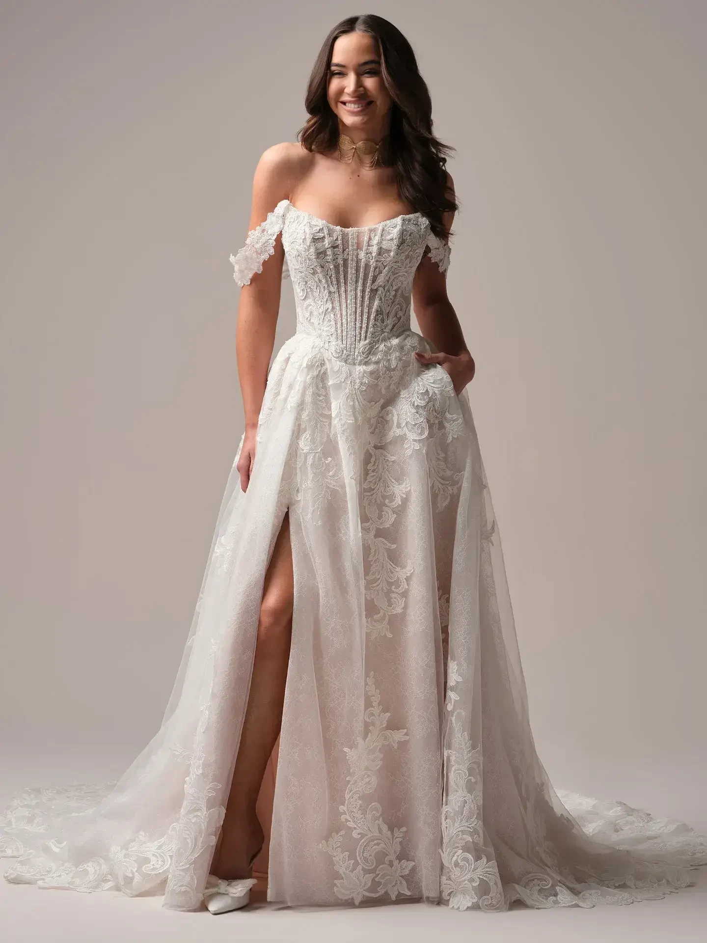 model is wearing an off the shoulder a-line wedding dress
