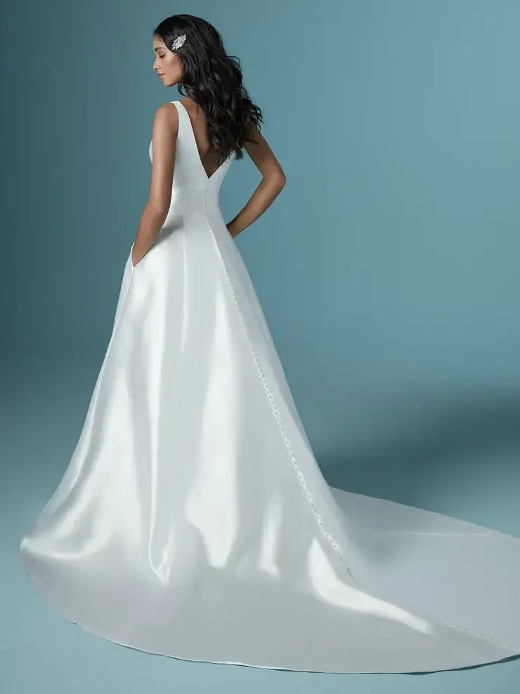 model is wearing a sleeveless a-line wedding gown